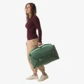 Eagle Creek Tour Travel Pack 40L Jungle Green — noszenie w dłoni, ujęcie lifestyle