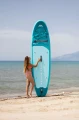 Deska SUP Aqua Marina Breeze postawiona pionowo na plaży