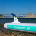 pompowana deska sup Gladiator Origin 10.8 SC – statecznik i burta deski przy wodzie, ujęcie lifestyle z krajobrazem w tle
