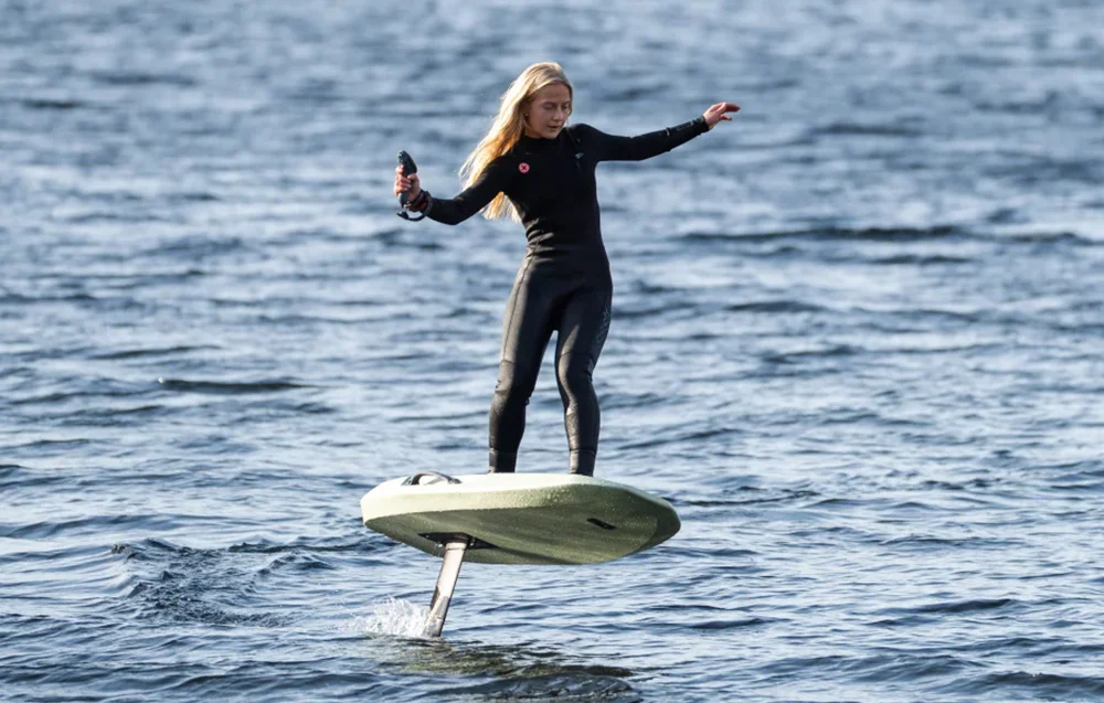 Dziewczyna pływa na elektrycznej desce eFoil Waydoo Flyer EVO Lite